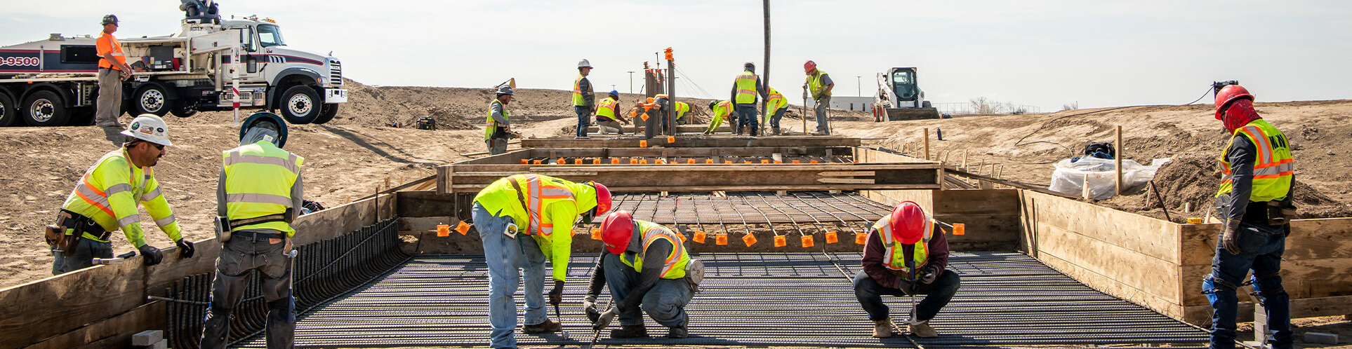workers laying rebar in preparation of laying concrete